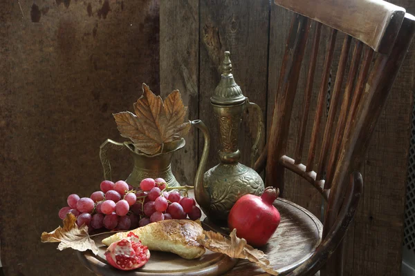 Stillleben mit Granatapfel, Trauben und Kupferkrug — Stockfoto