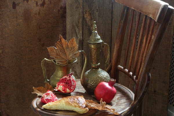 Still-life with a pomegranate, a pie and a copper jug