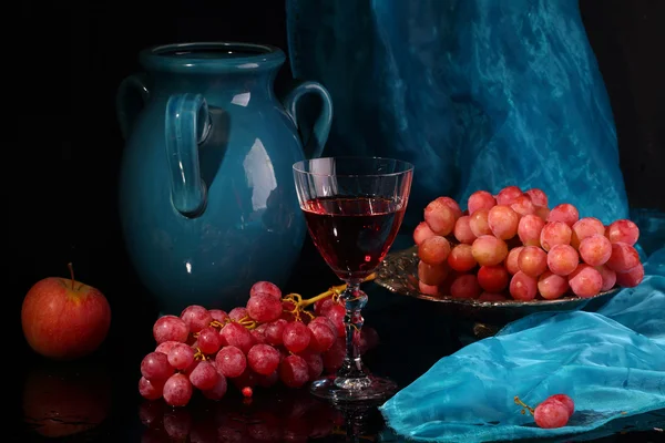 Vinho tinto e uvas rosa sobre um fundo preto — Fotografia de Stock