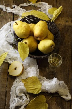 Beyaz şarap, armut gerdanlı bir sepet ve sonbahar bir şube