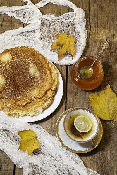 Chá com limão, panquecas, mel e folhas de outono — Fotografia de Stock