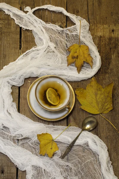 Thé au citron et feuilles d'automne sur une table en bois — Photo