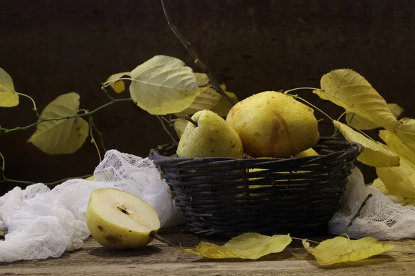 Груши в ваттной корзине, грецкие орехи и ветка осеннего ли — стоковое фото