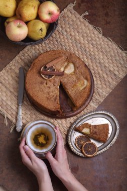 Bir fincan çay ve bir charlotte ile el tutar