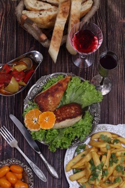 Bir gevrek, kızarmış patates ve bir bardak şarap tavuk fileto