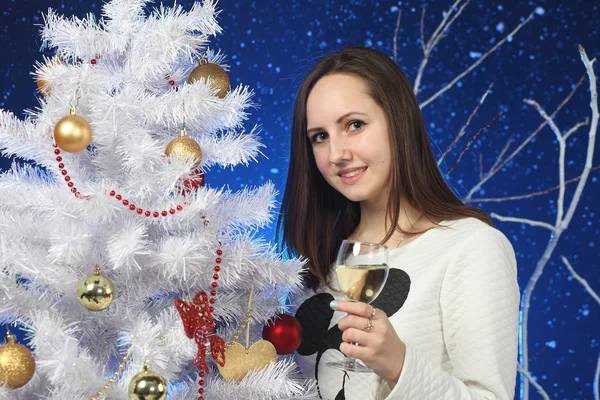La ragazza con un bicchiere di champagne in mani su un albero Di Capodanno — Foto Stock