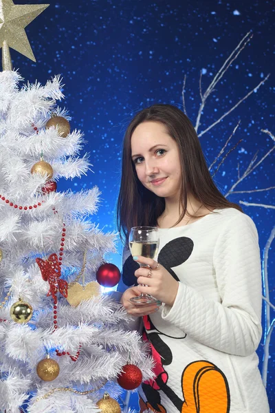 La ragazza con un bicchiere di champagne in mani su un albero Di Capodanno — Foto Stock
