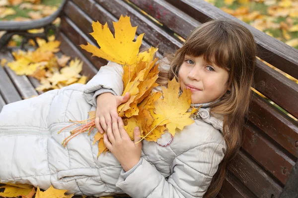 La chica con hojas de arce en el parque de otoño — Foto de Stock