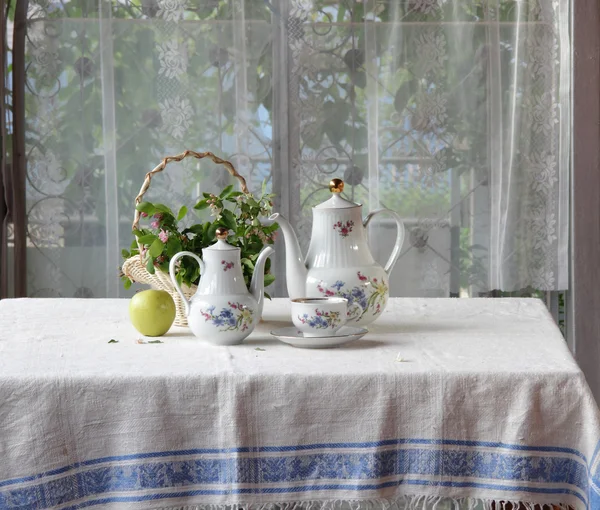 Tee in einer Tasse, ein grüner Apfel und ein Strauß — Stockfoto