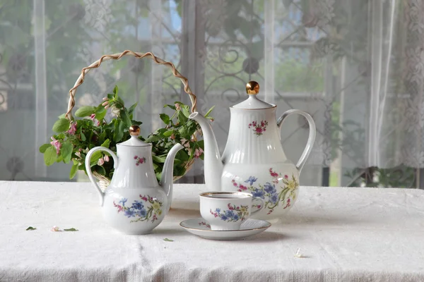 Te i en kopp, te service på ett bord med en vit duk — Stockfoto