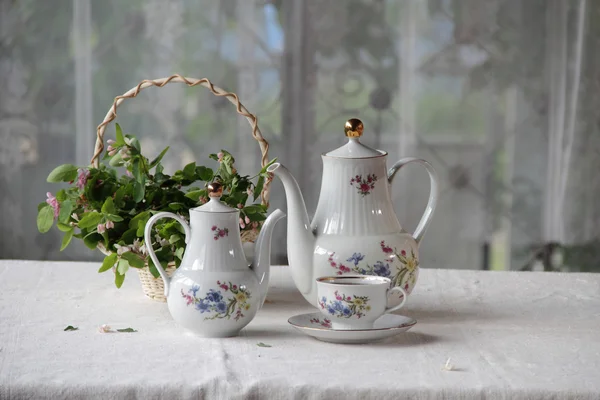 Te i en kopp, te service på ett bord med en vit duk — Stockfoto