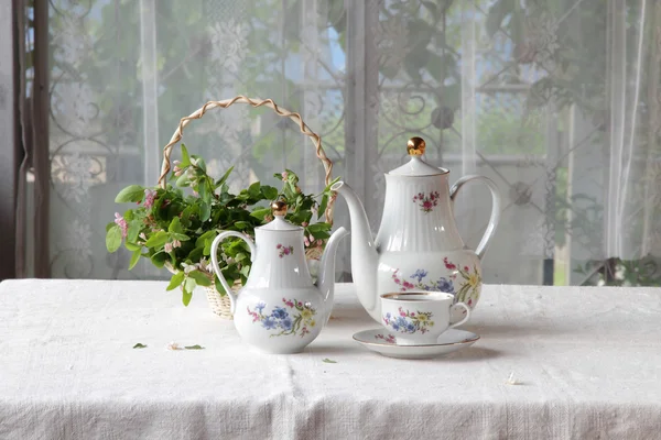Tee in einer Tasse, Teeservice auf einem Tisch mit einem weißen Tuch — Stockfoto