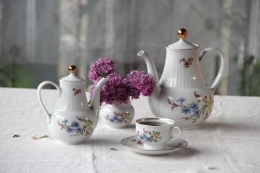 Çay bir fincan, leylak ve güzel bir hizmet bir buket