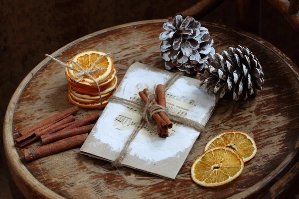 Still-life with cones, cinnamon and dried oranges on a wooden ta — Stock Photo, Image