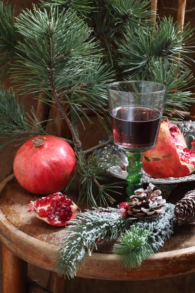 Новогодний натюрморт с красным вином, гранатом и сосновым бр. — стоковое фото