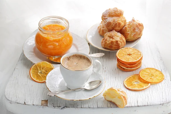 Cappuccino mit Eclairs und orangefarbenem Confiture — Stockfoto