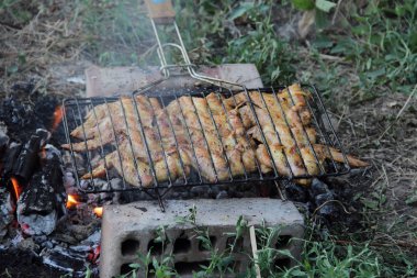 Bir kafes içinde bir mangal Barbekü için kulak kanatlarında