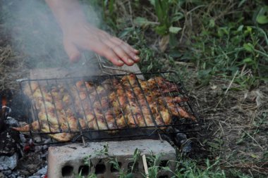 Bir kafes içinde bir mangal Barbekü için kulak kanatlarında