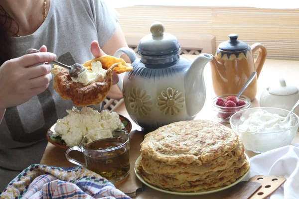 Female hands fill a pancake with cottage cheese — Stock Photo, Image