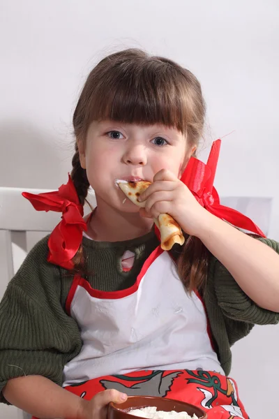 Дівчина їсть млинці зі сметаною — стокове фото
