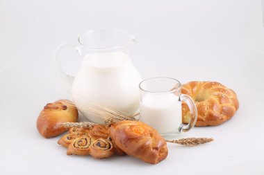 Süslü pasta ve şeffaf bir sürahi sütte rulo