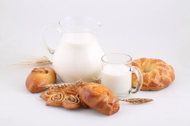 Süslü pasta ve şeffaf bir sürahi sütte rulo