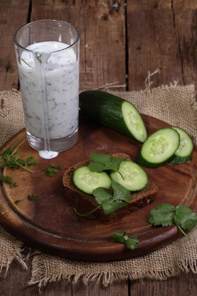 Cocktail from kefir with a cucumber on a wooden table — Stock Photo, Image