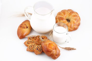 Süslü pasta ve şeffaf bir sürahi sütte rulo