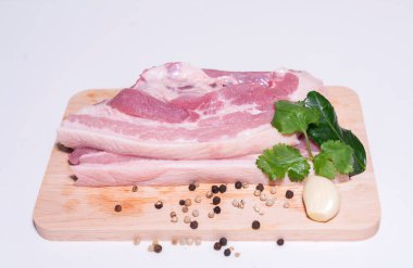 Ahşap kesme tahtasındaki domuz eti ve baharatlar pişirmeye hazır.