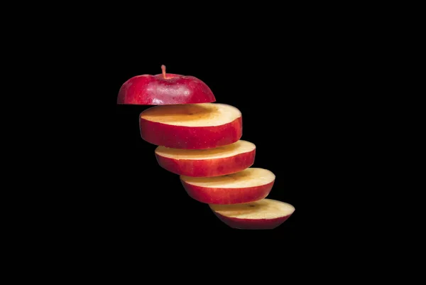 新鲜的红苹果切成片 在黑色背景上孤立地漂浮着 — 图库照片