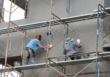 Teknisyenler duvarları duvardan sonra pürüzsüz ve güzel olması için kaplıyorlar..