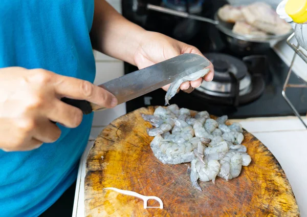 料理人は 掃除や調理のためにエビをカットするためにナイフを使用します — ストック写真
