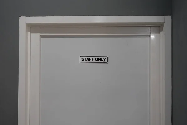 スタッフのみ というテキストの白いドアは その背後にある部屋へのアクセスは内部のみに制限されていることを伝えます — ストック写真
