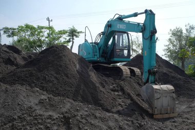 Klaten, Endonezya, 23 Haziran 2021. Mini kazıcı sanayi bölgesinde bir kum tepeciğine park etmiş.