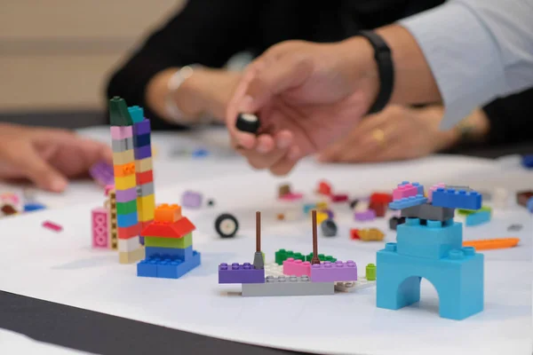 İş stratejisi ve insan kaynakları geliştirme simülasyonu olarak lego oynayan yetişkinlerin yakın çekimleri.