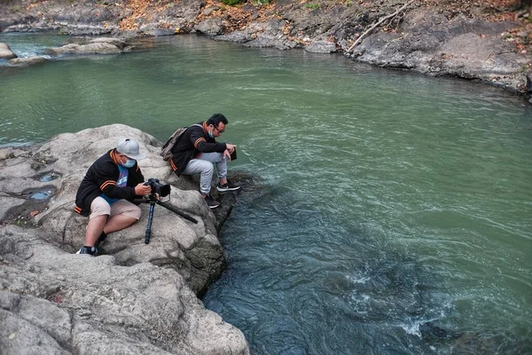 Yogyakarta, Endonezya, Sep 14, 2021. İki adam Lava Bantal nehri bölgesinde atış açısı arıyor. 