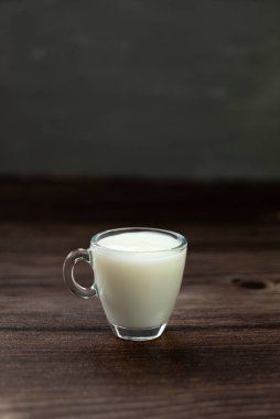 Siyah arka planda sütlü cam bardak.