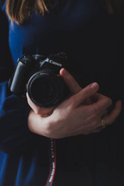 Fotoğrafçının elinde fotoğraf çekmek için bir kamera var.