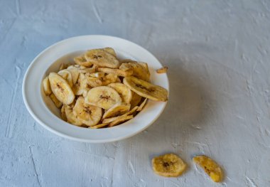 Arka planda muz cipsi olan seramik bardak