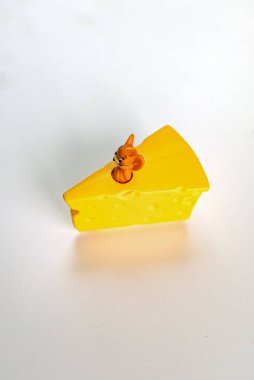 İçinde fare olan bir dilim sarı peynir.