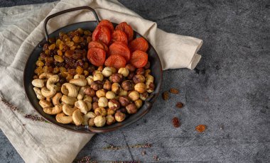 Yuvarlak tepside çeşitli fındık ve kurutulmuş meyveler.