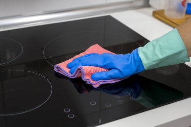 Evdeki masayı temizlemek mutfak masasının yüzeyini dezenfektan sprey şişesiyle sterilize etmek, yüzeyi eldivenlerle yıkamak. COVID-19 içeriden temizleme.