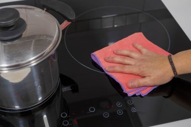 Evdeki masayı temizlemek mutfak masasının yüzeyini dezenfektan sprey şişesiyle sterilize etmek, yüzeyi eldivenlerle yıkamak. COVID-19 içeriden temizleme.