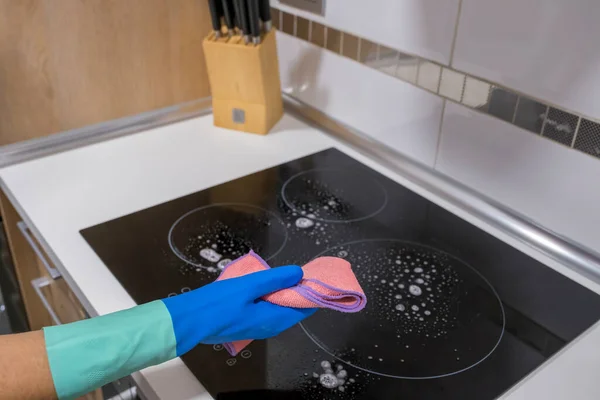 Cleaning the table in the house Sanitize the surface of the kitchen table with a disinfectant spray bottle, wash the surfaces with gloves. COVID-19 prevention indoor sanitizing.
