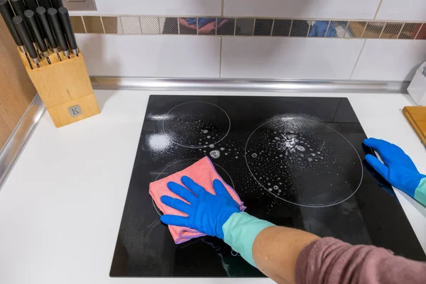 Cleaning the table in the house Sanitize the surface of the kitchen table with a disinfectant spray bottle, wash the surfaces with gloves. COVID-19 prevention indoor sanitizing.