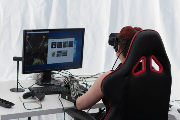 Chica joven con VR - gafas juega juego en PC en Animefest —  Fotos de Stock