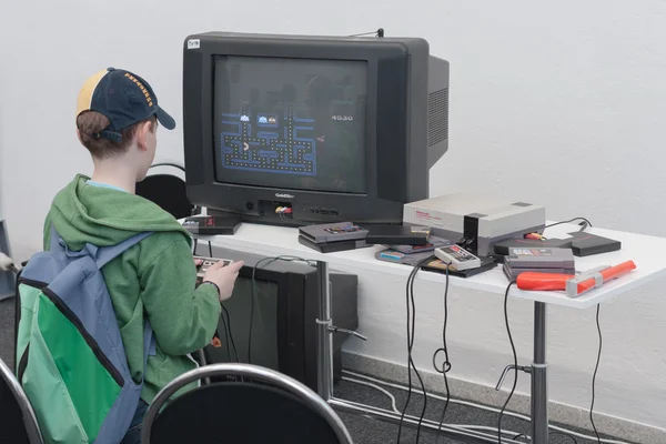 Boy juega consola de juegos con la televisión en Animefest —  Fotos de Stock