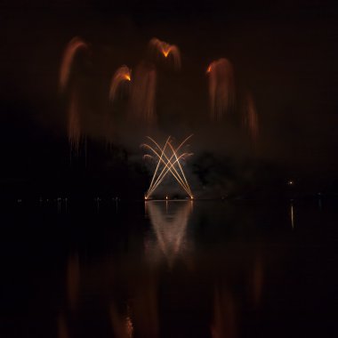 Göl üzerinde yansıması ile renkli havai fişek.