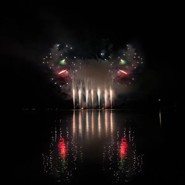 Fuegos artificiales coloridos con reflexión sobre el lago . — Foto de Stock