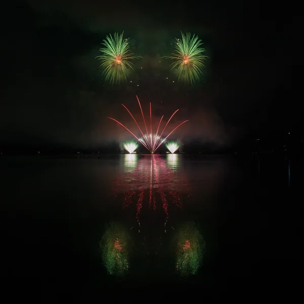 Farbenfrohes Feuerwerk mit Spiegelung am See. — Stockfoto